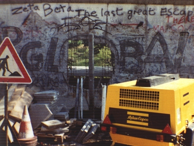 Nel '91 il muro era ancora molto presente, rotto in molti punti come in questa foto, dove un buco forma la o di *global*