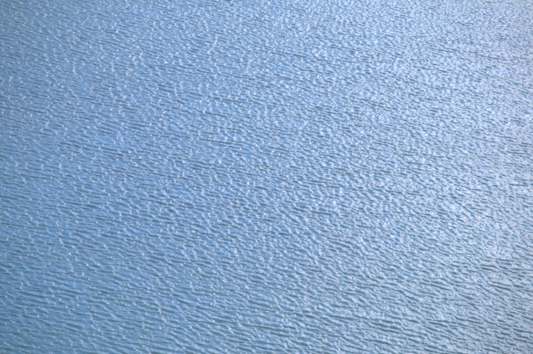L'acqua è azzura sotto il sole e manda riflessi da tante piccole onde.